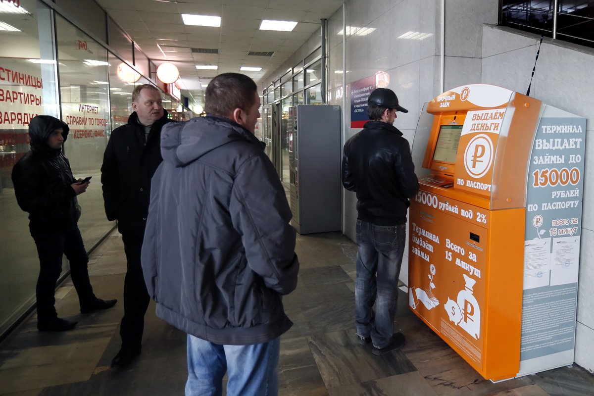 Очередь у автомата, выдающего микрозаймы на Курском вокзале в Москве. Фото: Юрий Кочетков / EPA